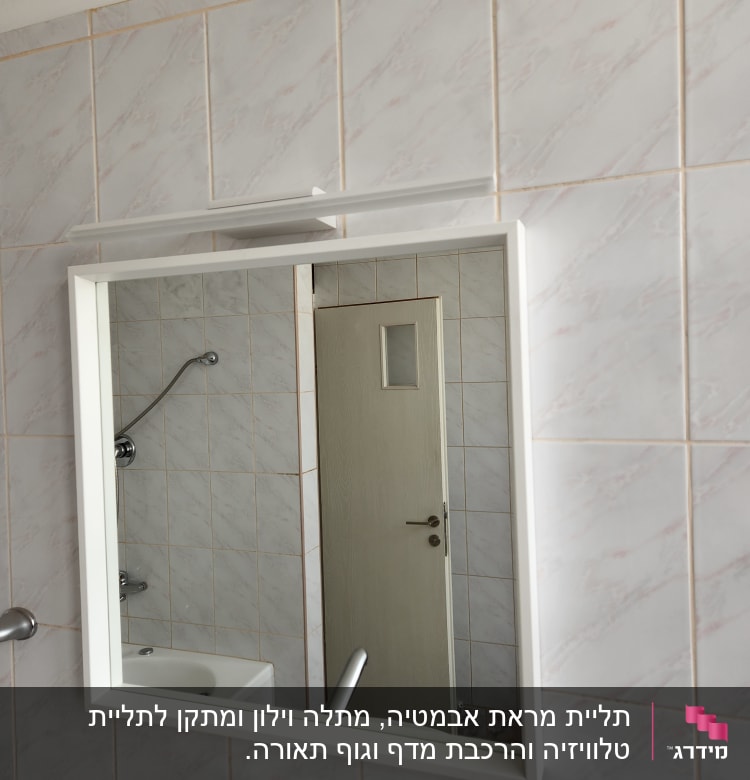 מראה תלויה על קיר אריחים בחדר אמבטיה